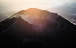 the sun shines on the top of a mountain