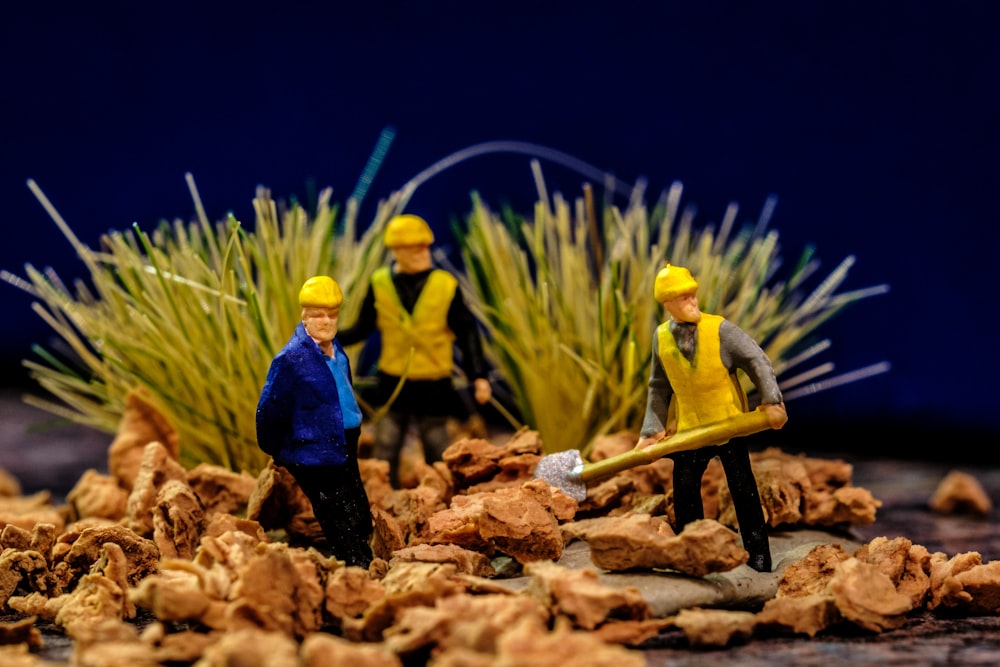 a group of toy figurines standing on top of a pile of rocks