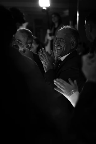 Smiling guests clapping and enjoying a magic show at an elegant event.