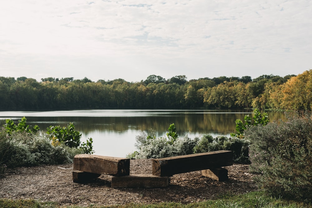 a wooden bench sitting in front of a lake