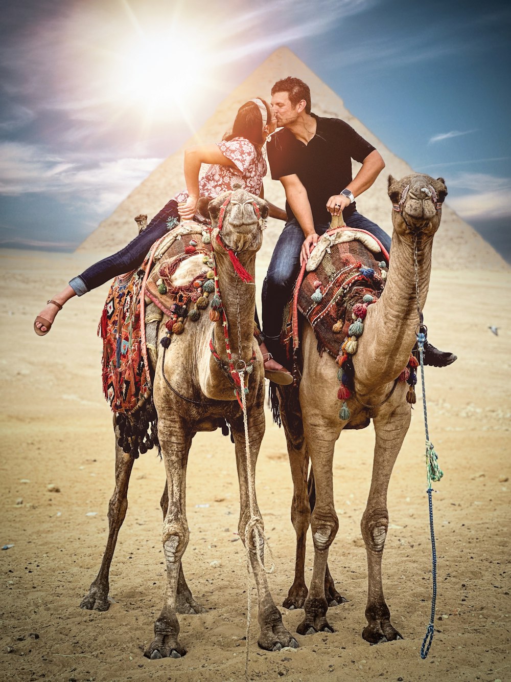 a man and a woman riding on the back of a camel