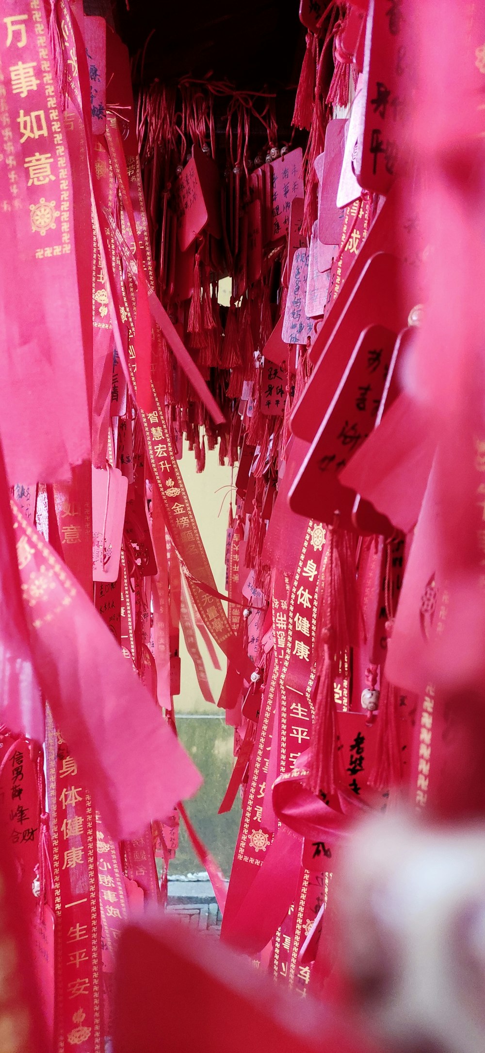 a bunch of pink ribbons hanging from a ceiling