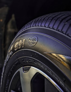 Close-up of a high-quality car tire with detailed tread pattern on a clean workshop floor