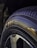 A close-up view of a car tire featuring detailed tread patterns and branding information such as text and logos. The tire surface appears glossy, with the focus on the sidewall markings and tread design.
