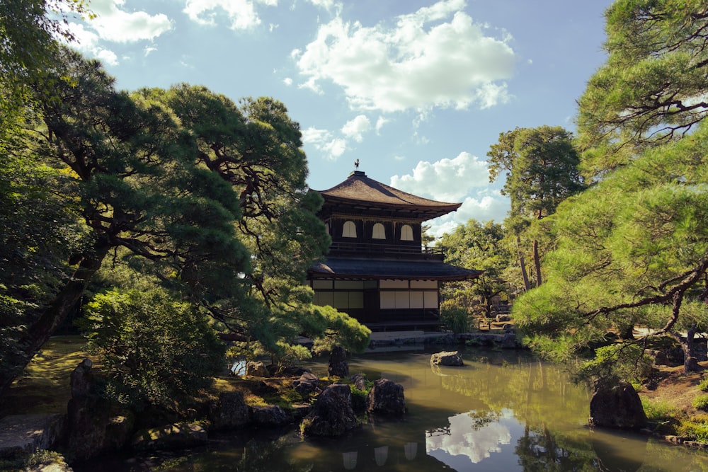 a pagoda in the middle of a pond surrounded by trees