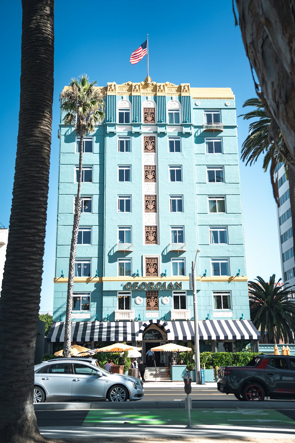 a tall blue building with a flag on top of it