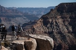 a group of people standing on top of a cliff