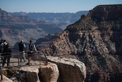a group of people standing on top of a cliff