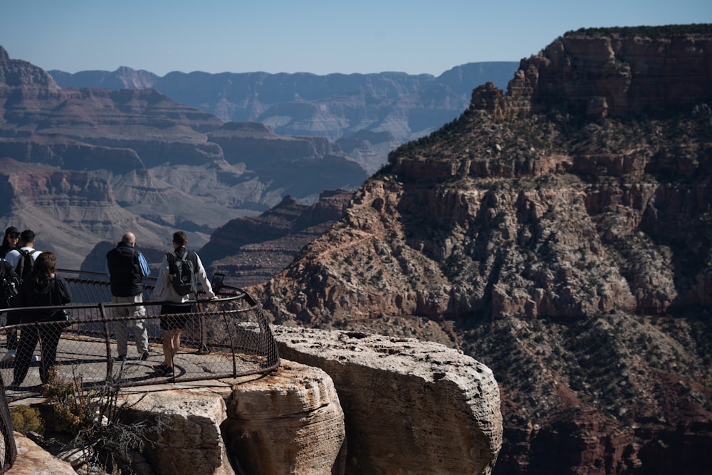 a group of people standing on top of a cliff