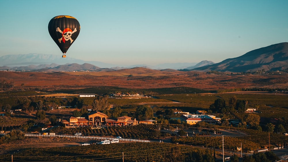 a hot air balloon flying over a small town