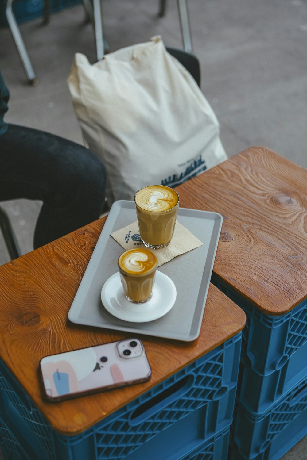 two cups of coffee on a tray on a table