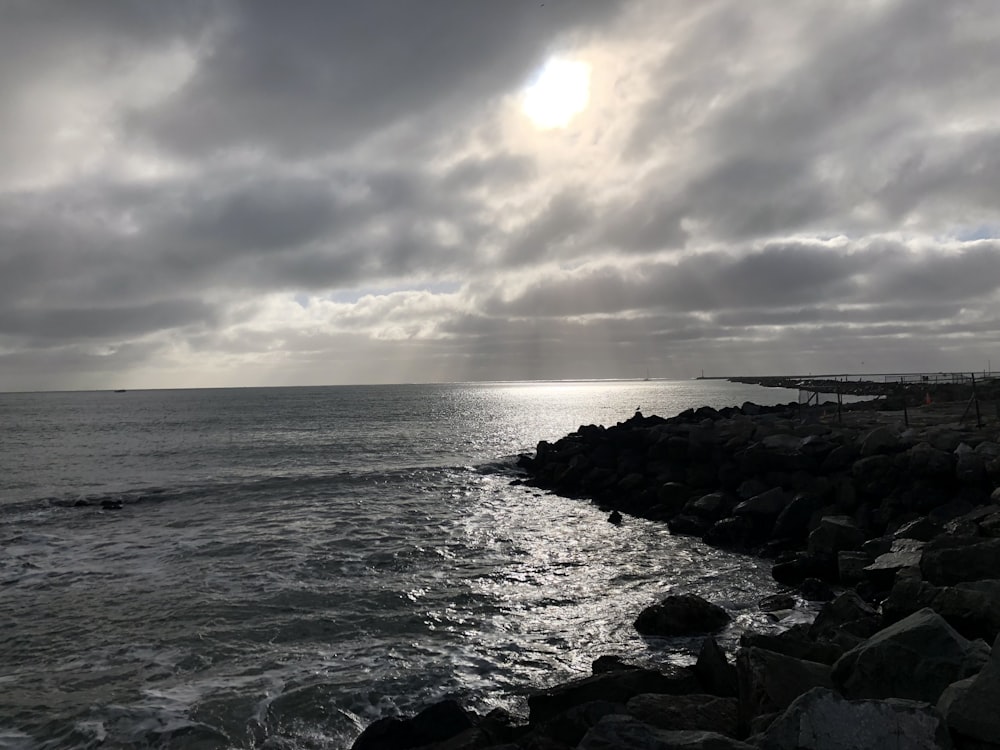 a body of water sitting next to a rocky shore