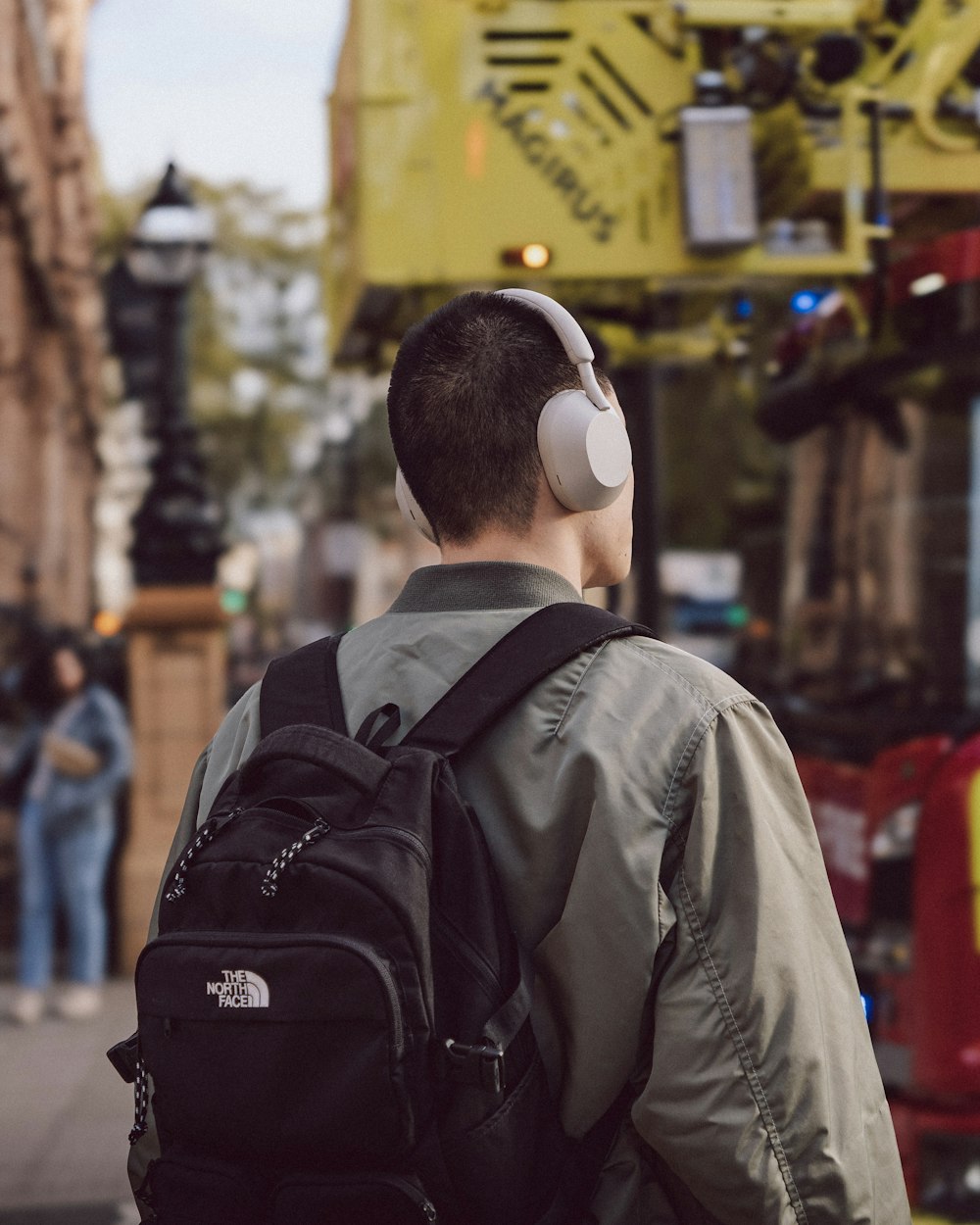 a man with headphones on walking down the street