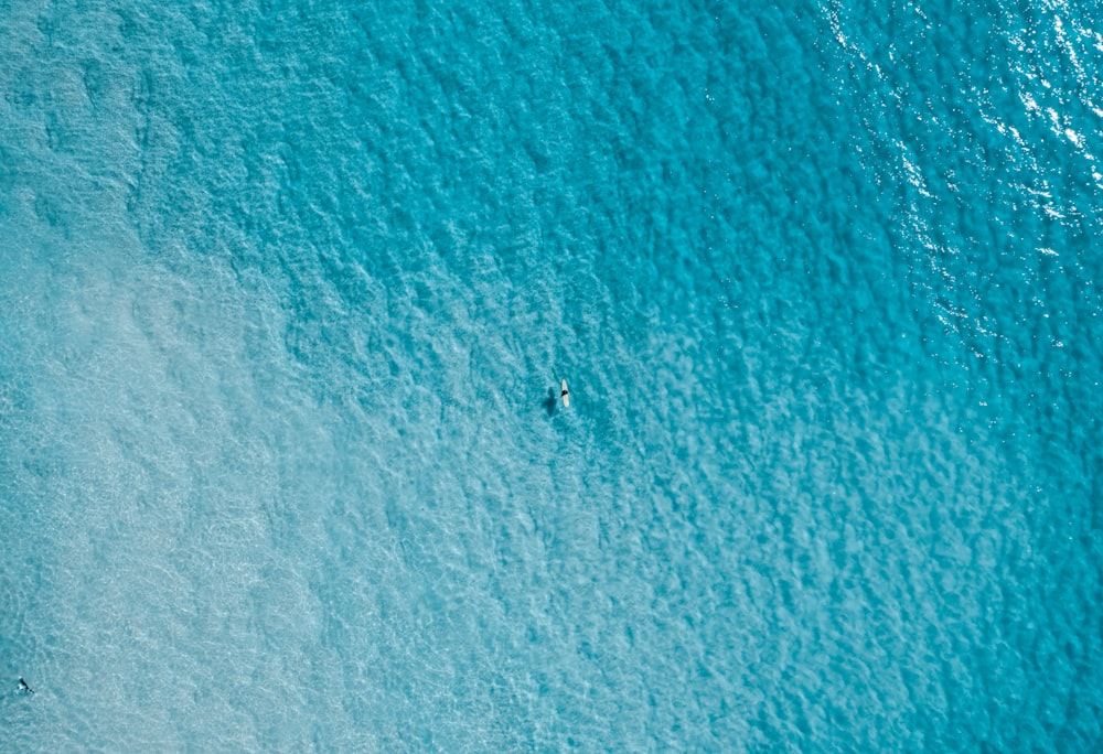 a couple of people riding on top of a wave in the ocean