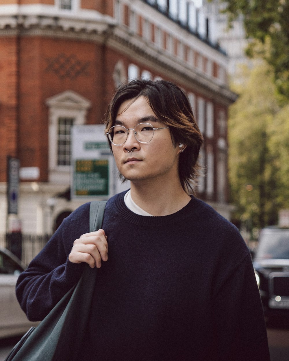 a man with glasses is walking down the street