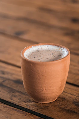 Fresh buttermilk poured into traditional clay cups on a sunny morning.