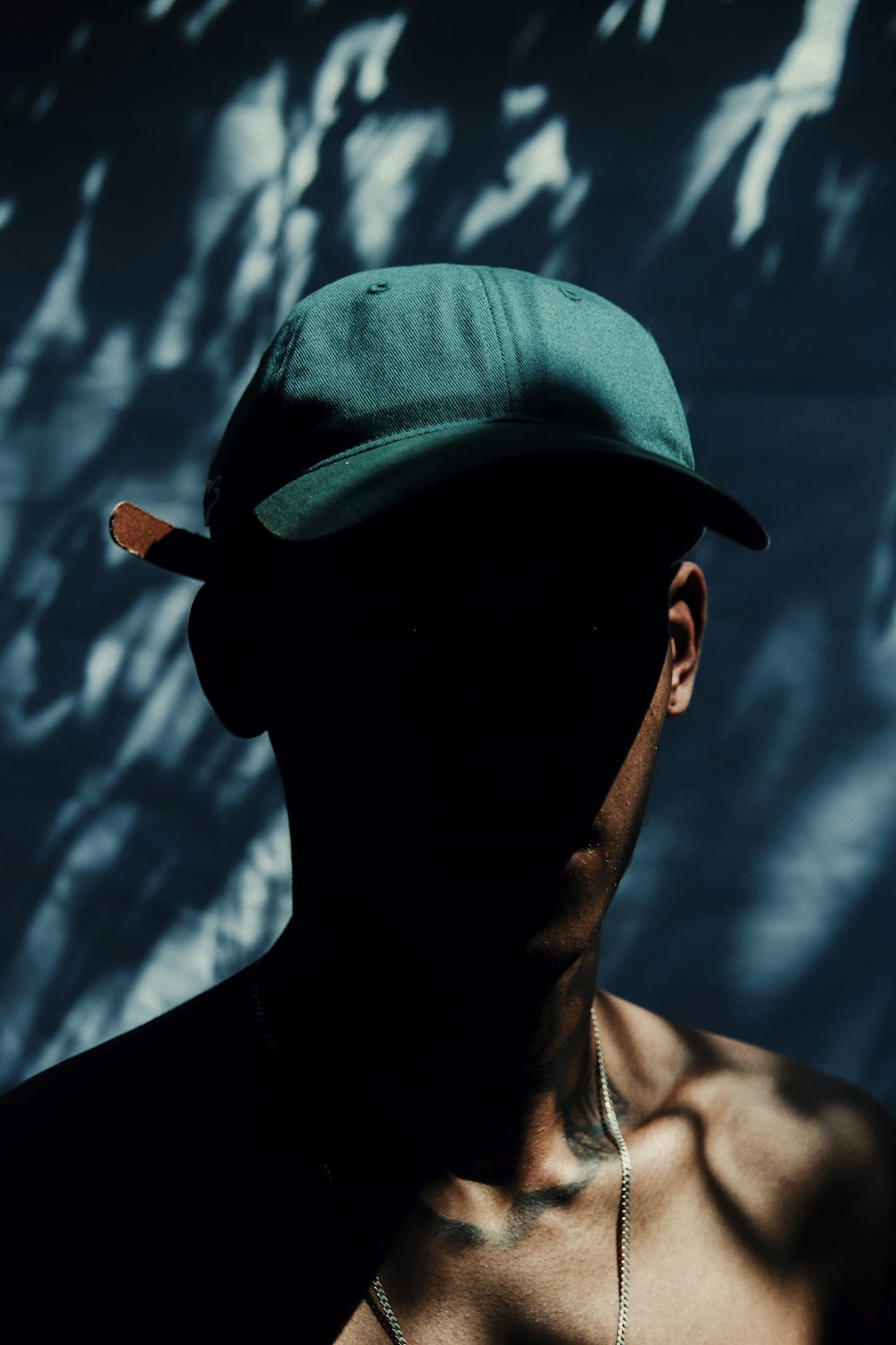 a man wearing a green hat and a necklace