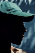 a man wearing a green hat and a black shirt