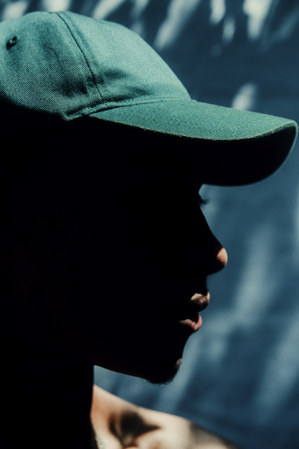 a man wearing a green hat and a black shirt