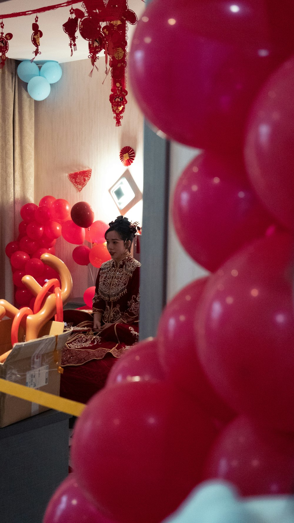 a woman sitting in a room filled with balloons