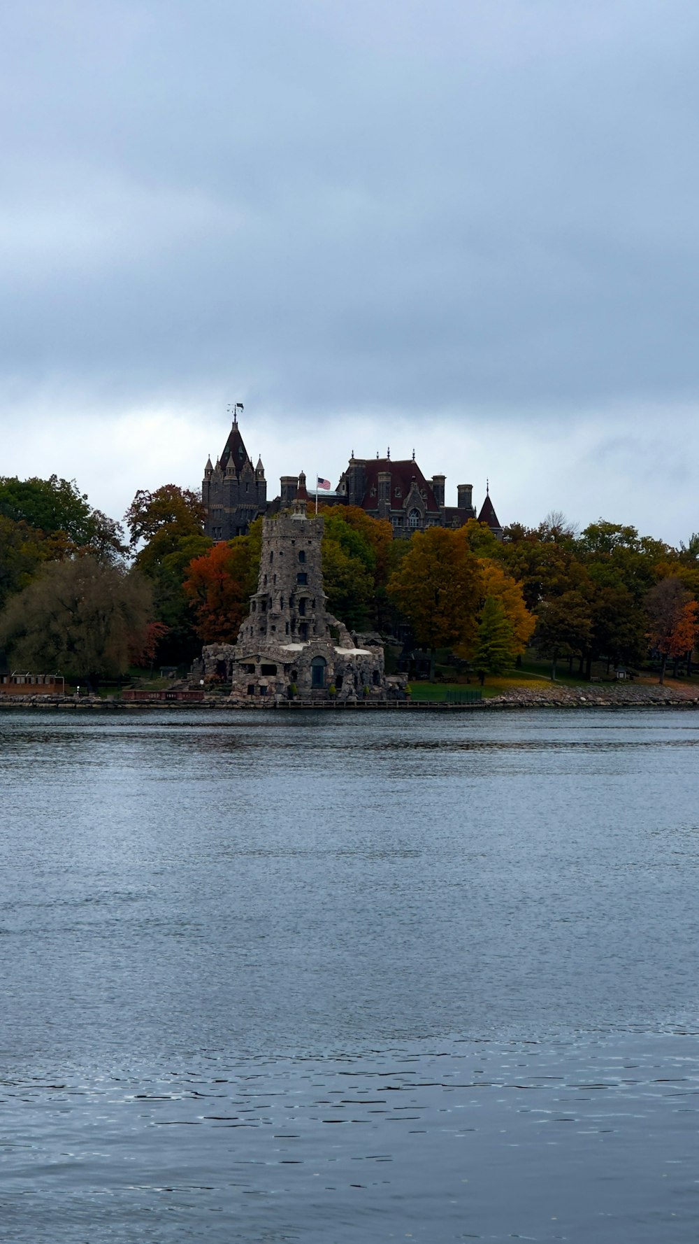 a large building sitting on top of a lake next to a forest