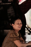 a woman sitting at a table smiling for the camera