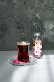 A delicate tea blend jar adorned with a purple orchid label resting on a gold-accented wooden table.