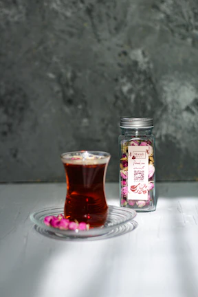 A delicate tea blend jar adorned with a purple orchid label resting on a gold-accented wooden table.