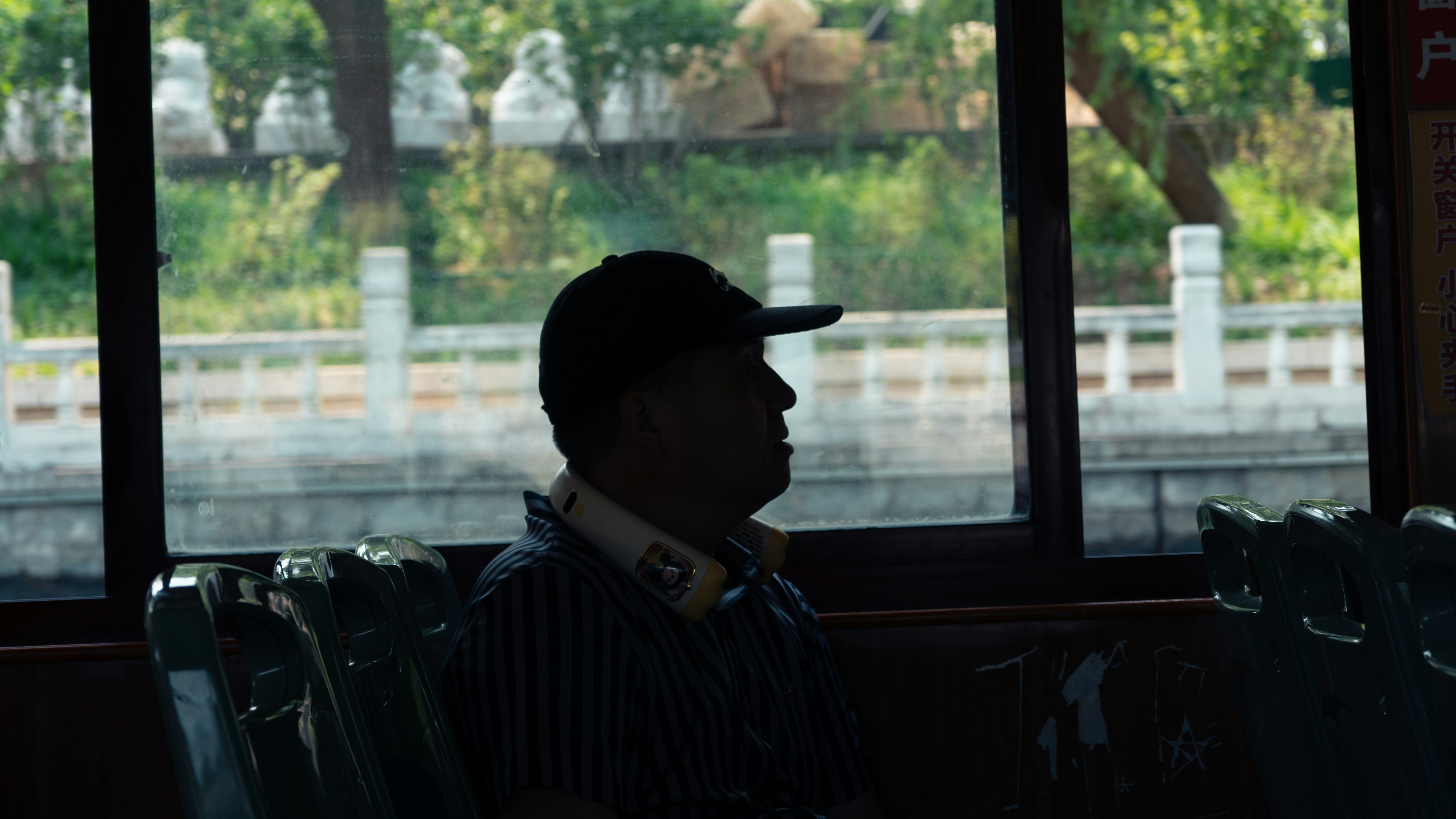 A man sitting on a bus looking out the window photo – Free Car Image on ...