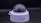 A close-up view of a dome-shaped security camera mounted on a surface. The camera's transparent cover is slightly fogged up. The setup appears to be professional, with visible wiring extending from the back.