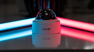 Modern CCTV setup glowing with blue neon lighting in a futuristic home and office background.