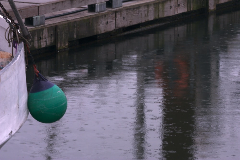 a green buoy hanging from the side of a boat