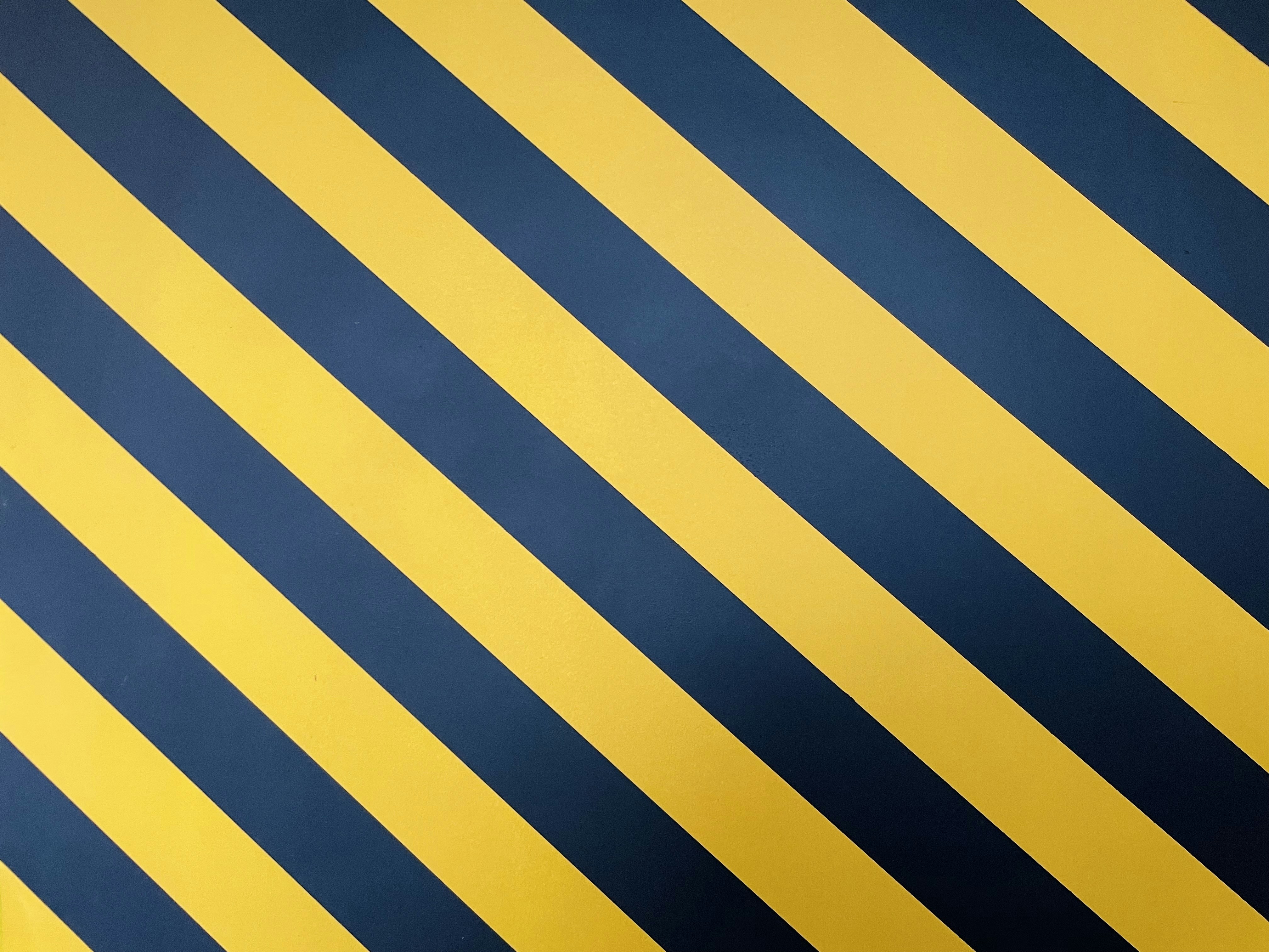 a black and yellow striped wallpaper with vertical stripes