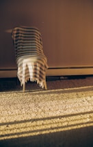 A throw blanket casually tossed on a chair bathed in warm afternoon light.