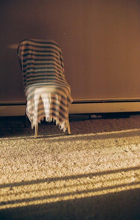 A cozy, stylish hoodie draped over a wooden chair in a sunlit room.