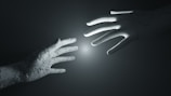 A close-up of a futuristic robotic hand interacting with a screen.