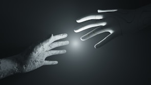 A close-up of a futuristic robotic hand interacting with a screen.