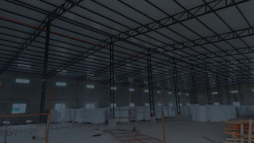 Modern warehouse interior with stacks of bulk denim ready for export, bathed in industrial silver and indigo lighting.