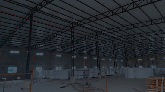 Stacked rolls of plastic packaging material in a bright industrial warehouse.