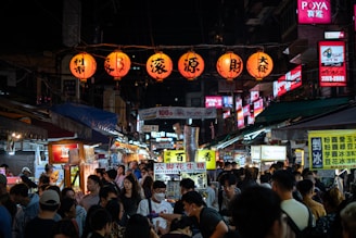 a crowd of people walking down a street at night