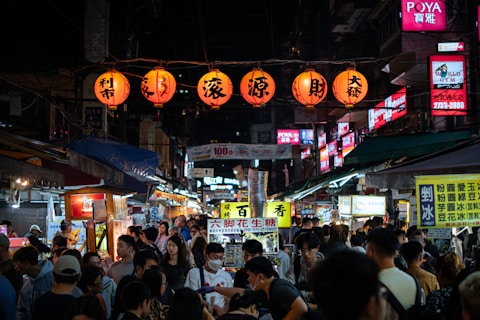 a crowd of people walking down a street at night