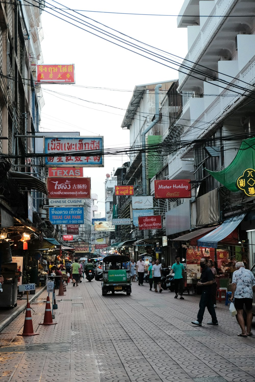 a city street with many signs and people walking around