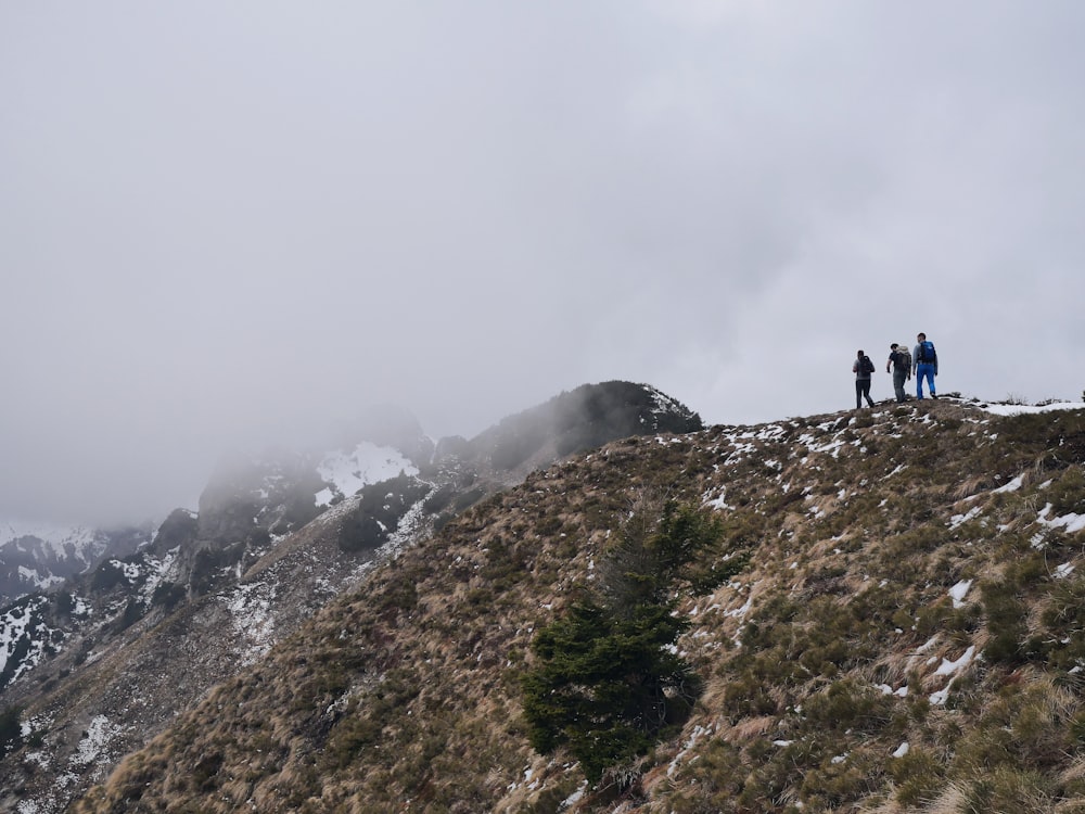a group of people standing on top of a mountain