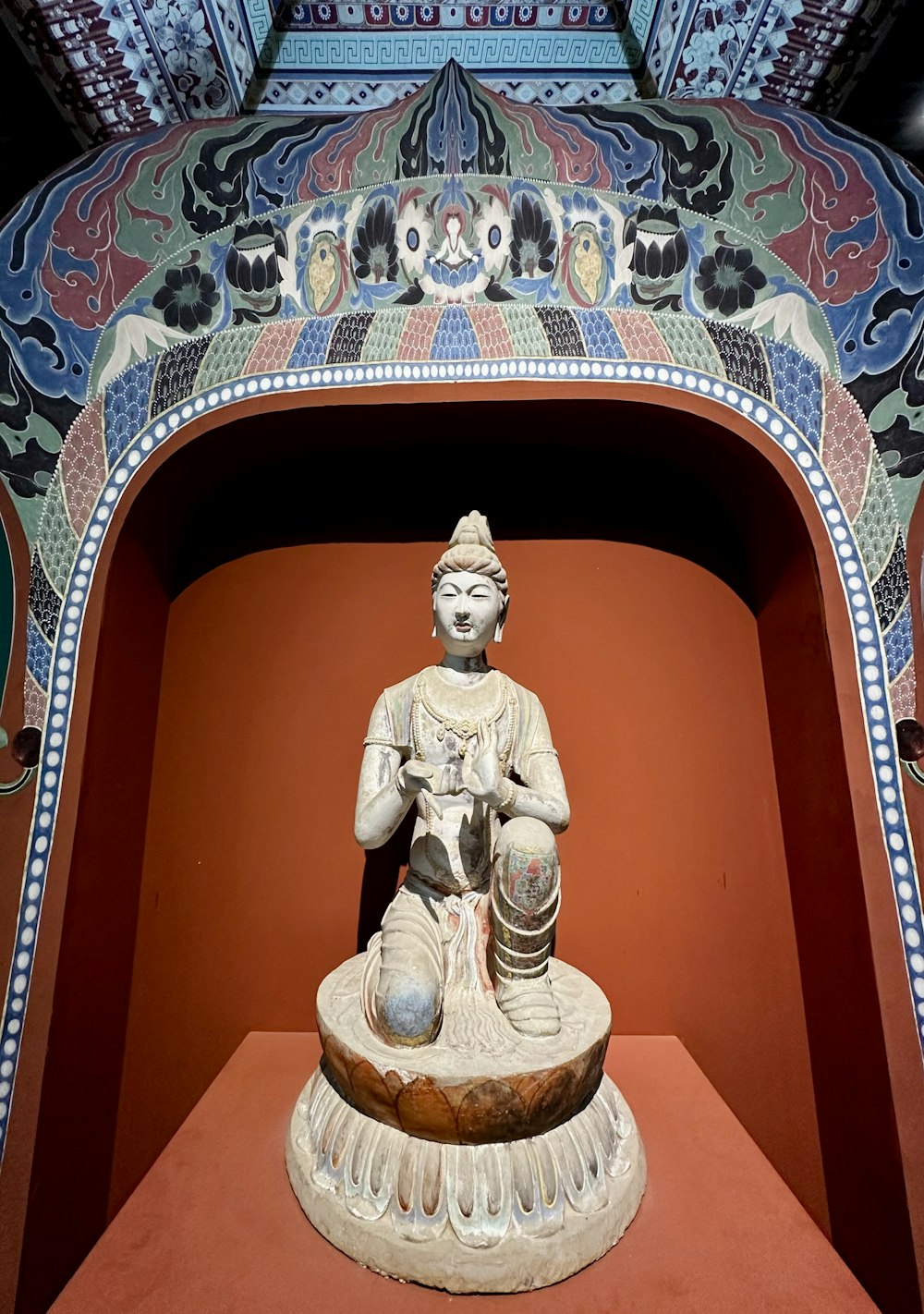 a statue of a person sitting on a bowl