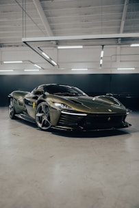 A sleek, dark green car being carefully inspected by a professional in a modern showroom.