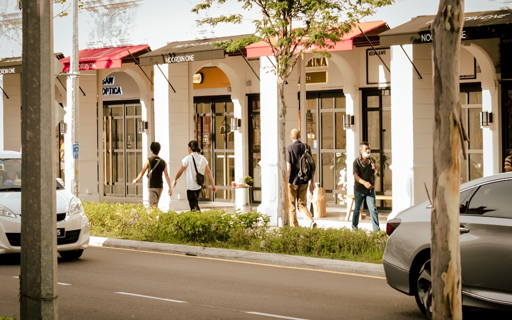 a group of people walking down a street next to a building