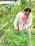 A happy woman tending to her flourishing garden with bright green plants.