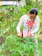 A happy woman tending to her vibrant garden using sleek green garden tools.