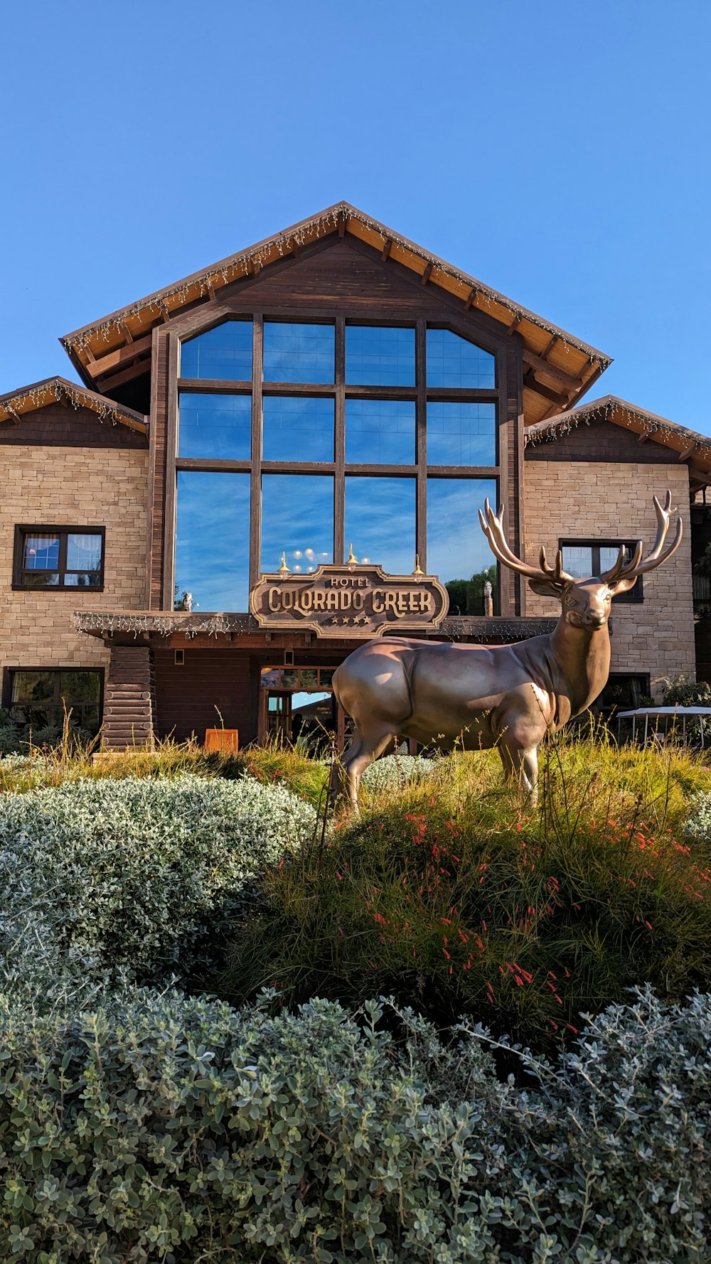 a statue of a deer stands in front of a building