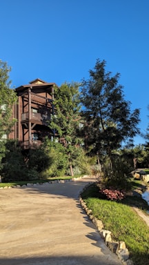 A dignified lodge building entrance framed by lush greenery under a clear sky.